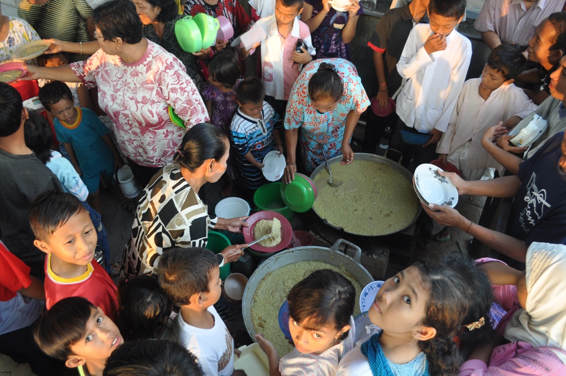 Dengan berbagai wadah, warga mengantre bubur sura di Masjid Astana Tuban, kompleks makam Sunan Bonang.