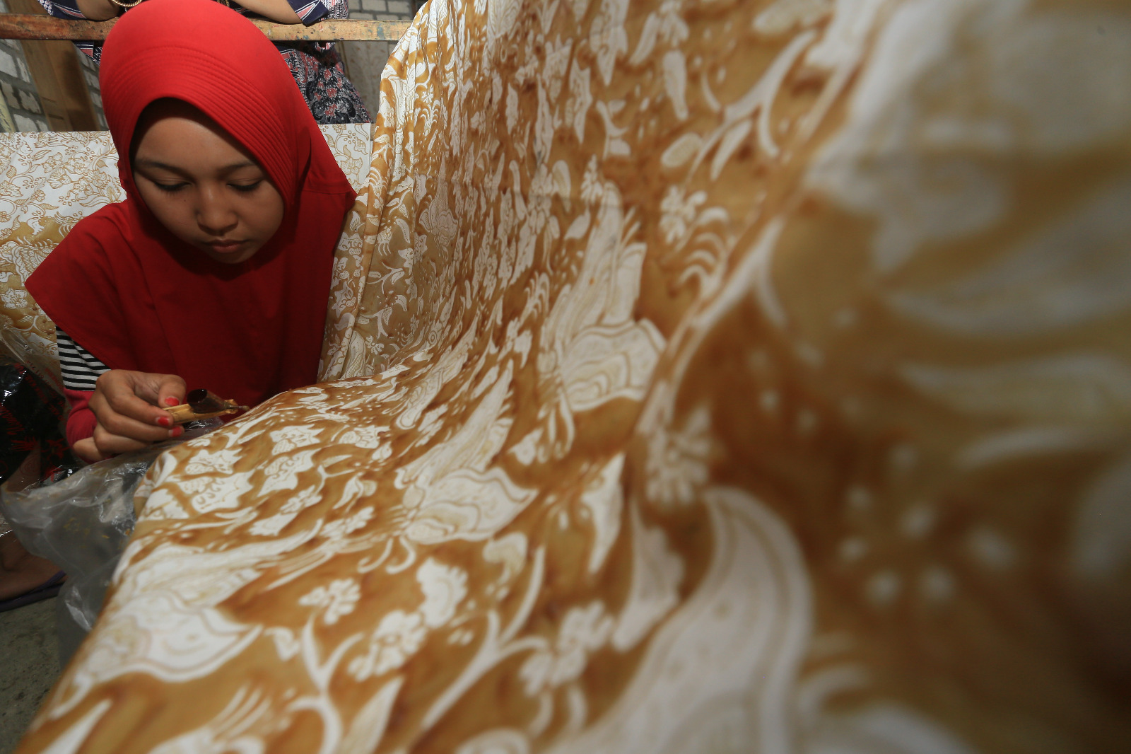 Pembatik memberi malam pada kain bakalan batik gedog di Kecamatan Kerek, Kabupaten Tuban, Jawa Timur.