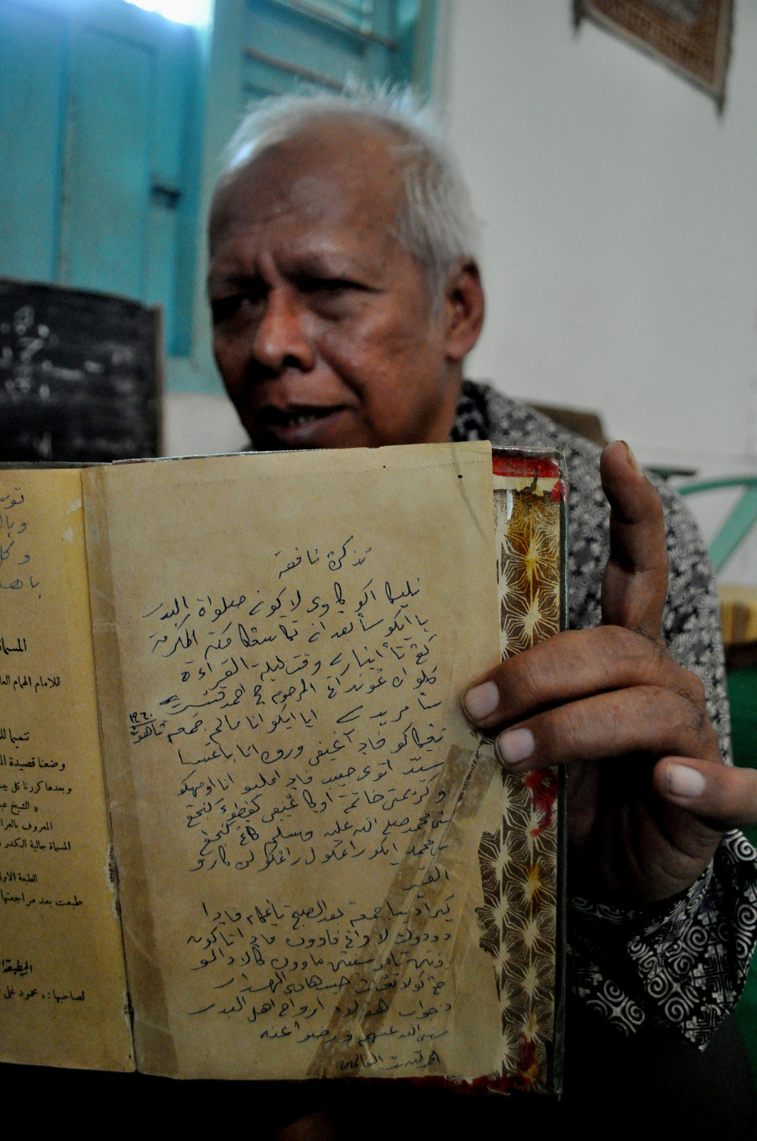 Kiai Achmad Syakir Ali, putra KH R. Muhammad Ali Manshur as-Shiddiqi menunjukkan manuskrip Sholawat Badar di rumahnya,  Desa Maibit, Kecamatan Rengel, Kabupaten Tuban, Jawa Timur.