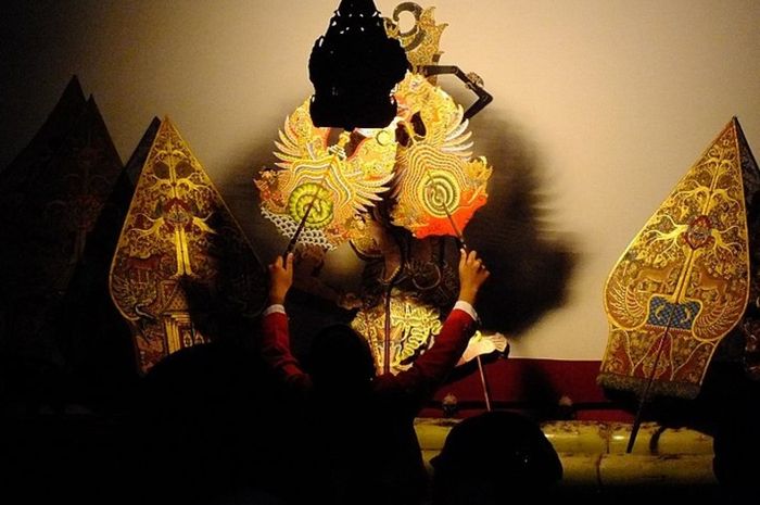 Ilustrasi foto dalang sedang dalam petunjukan wayang.