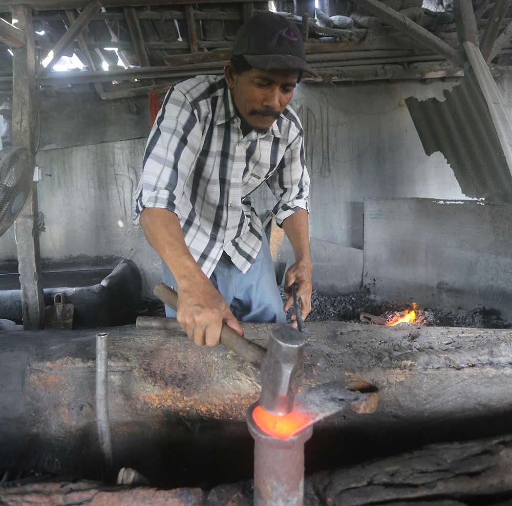 Sugeng membuat golok di bengkel pande besinya di Desa Sumberarum, Kecamatan Kerek, Kabupaten Tuban, Jawa Timur.