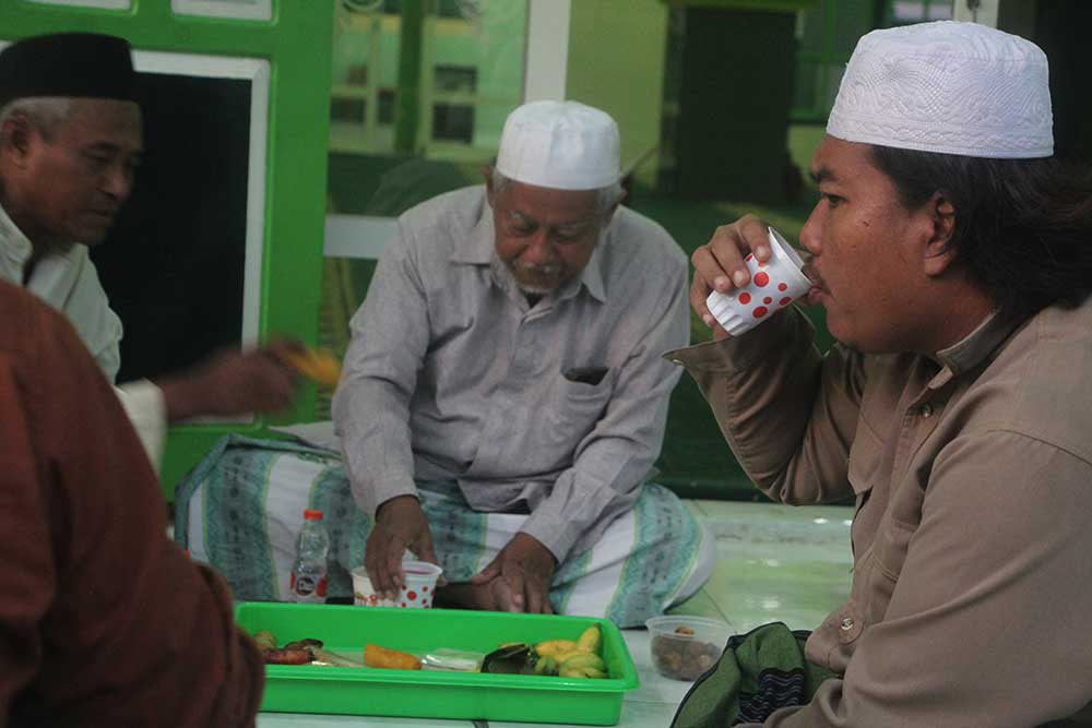 KEBERSAMAAN: Suasana buka puasa bersama warga sekitar di teras Masjid Baitul Makmur, Minggu (24/3).