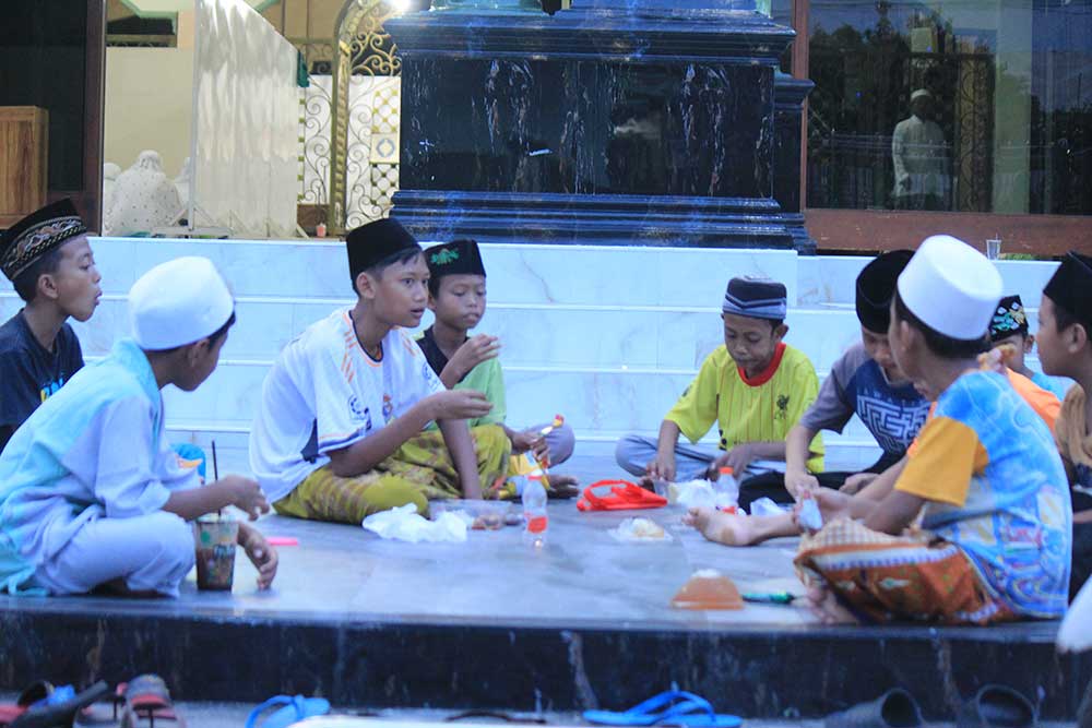 JAGA KERUKUNAN: Sejumlah anak-anak menikmati sajian buka puasa di teras Masjid Baitur Rohim, Minggu (31/3).
