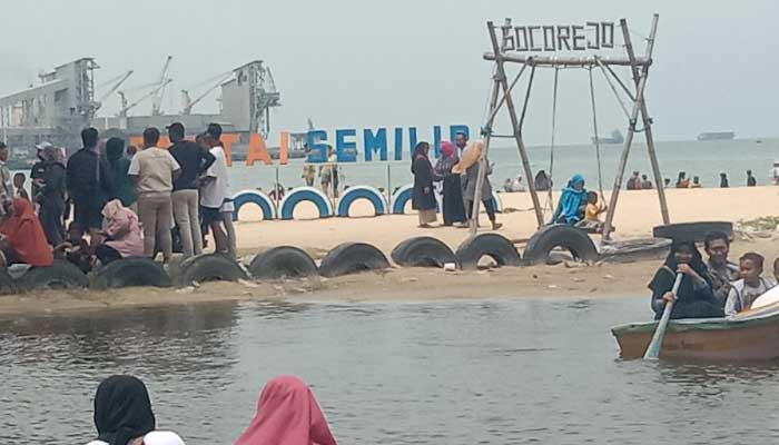 Pengunjung naik perahu tradisional di Pantai Semilir Tuban. Foto diambil pada Januari 2022.