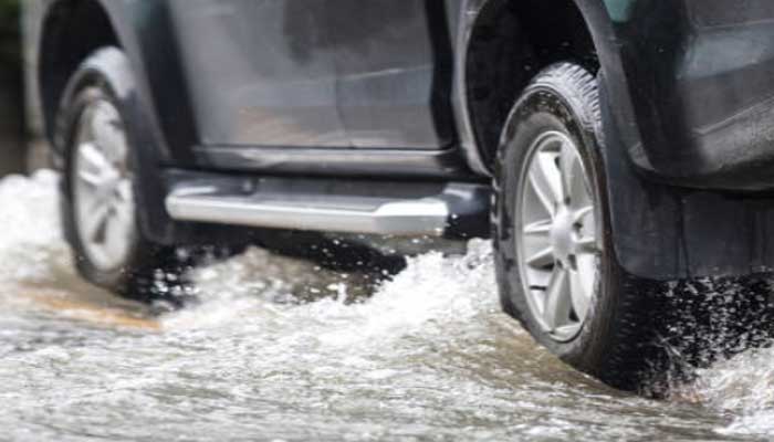 Ilustrasi mobil melintasi genangan air. Ada tips langkah untuk tindakan pertama saat mobil terkena banjir, tindakan yang tepat mencegah terjadinya kerusakan lebih lanjut pada mobil.