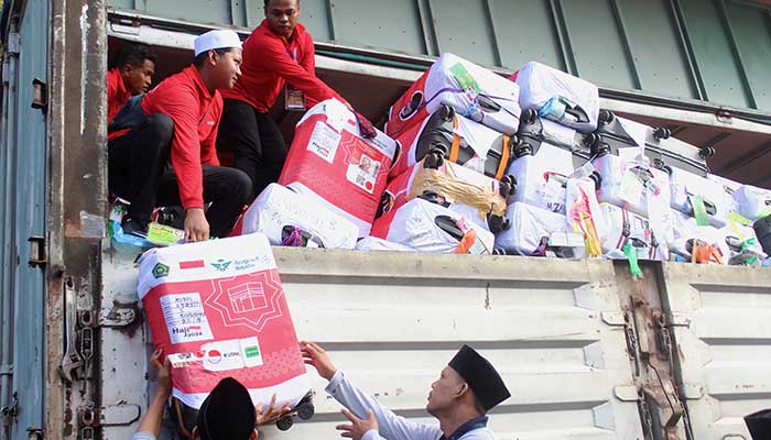 Ilustrasi petugas mengangkut barang bawaan jemaah haji.