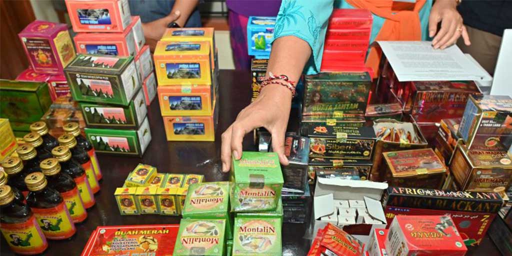 Petugas menunjukkan obat tradisional ilegal hasil operasi penindakan di Denpasar, Bali, Kamis (12/6).