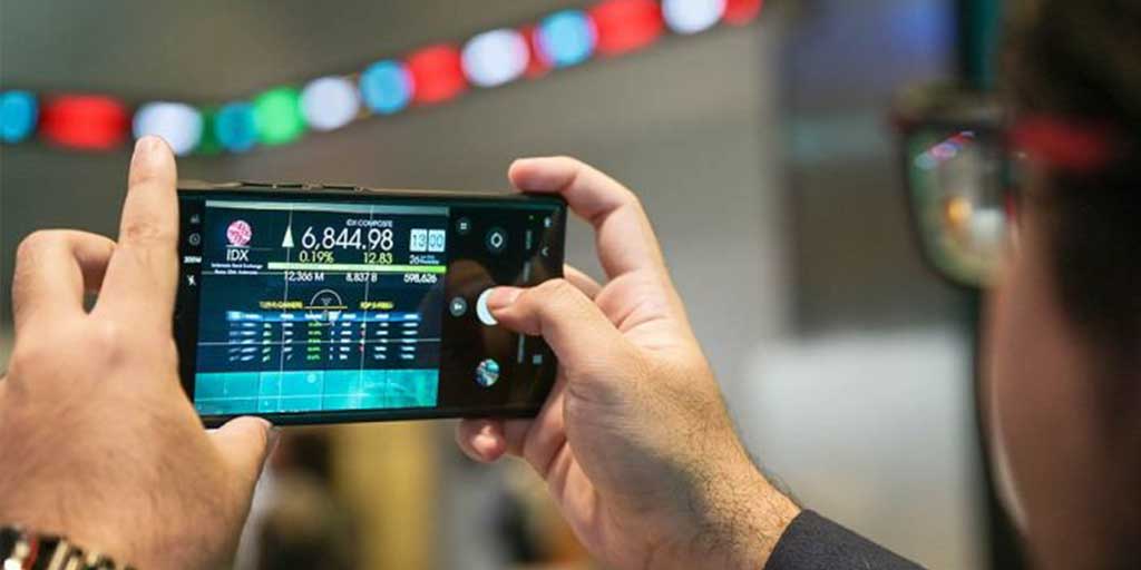 Pengunjung mengambil gambar layar digital pergerakan Indeks Harga Saham Gabungan (IHSG) di Bursa Efek Indonesia (BEI), Jakarta, Kamis (26/6).