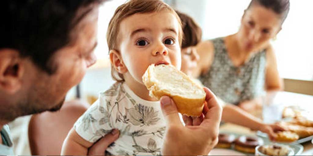 Ilustrasi bayi makan roti.