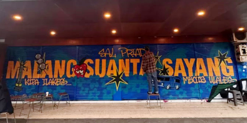 Mural bertuliskan &ldquo;Malang Suantai Sayang&rdquo; menghiasi salah satu sudut kota, menjadi latar utama video musik terbaru Sal Priadi yang dipersembahkan untuk kampung halamannya, Malang.