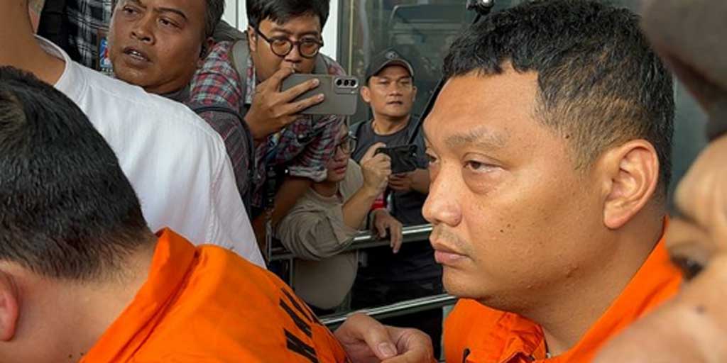 Irvian Bobby Mahendro (kanan) saat berjalan menuju mobil tahanan di Gedung Merah Putih KPK, Jakarta, Jumat (22/8).