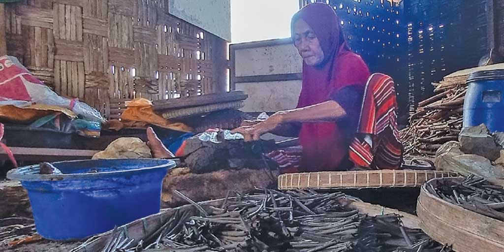 Mbah Rasimah tengah menyerut blok tanah liat hitam untuk dijadikan gulungan ampo, Selasa (9/9).