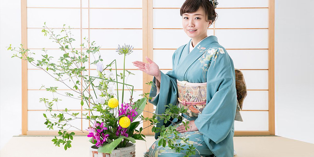 Perempuan Jepang berkimono memperagakan seni Ikebana, tradisi merangkai bunga khas Jepang yang melambangkan harmoni dan ketenangan.