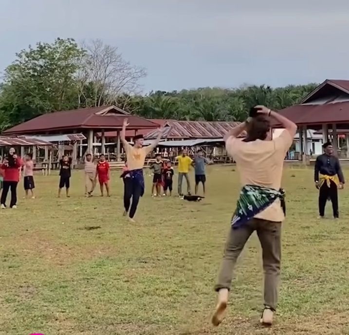 Momen seru saat teman-teman Max bersorak gembira setelah ia berhasil memasukkan bola ke payung dalam permainan tradisional Sepak Rago Tinggi di Kuantan Singingi, Riau.