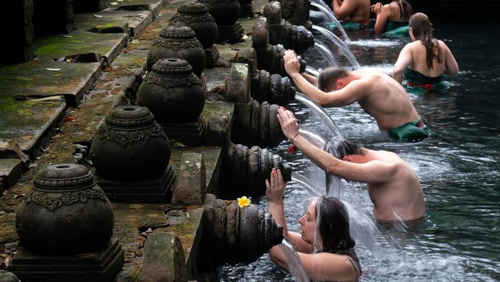 Wisatawan domestik dan mancanegara melakukan ritual melukat di pancuran suci Pura Tirta Empul, Gianyar, Bali. Tradisi penyucian diri ini kini jadi simbol spiritual detox yang mendunia.