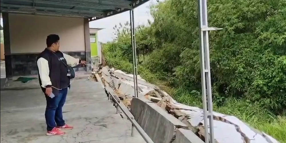 Warga menunjuk bagian Puskesmas Jatirogo yang ambles usai diguyur hujan dua hari. Bangunan Rp4,2 miliar itu kini nyaris tak bisa difungsikan.