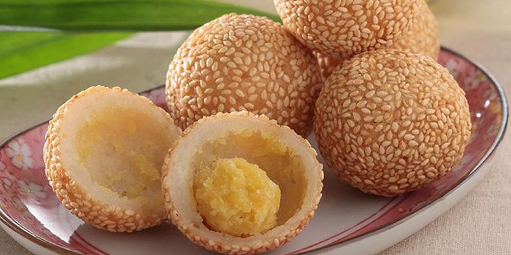 Onde-onde klasik dengan lapisan wijen keemasan dan isian kacang hijau kering padat, hasil dari teknik goreng anti meletup yang kini banyak dipakai pelaku UMKM.
