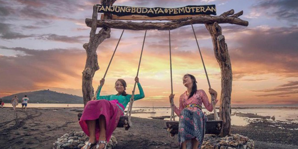 Wisatawan menikmati senja di Pantai Pemuteran, ikon wisata berkelanjutan Bali.