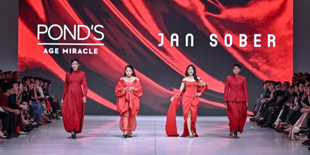 Sher, penjual sosis asal Tegal, melangkah penuh percaya diri di panggung JFW 2026. Penampilannya dalam busana merah rancangan Jan Sober menjadi simbol keberanian perempuan Indonesia untuk bermimpi