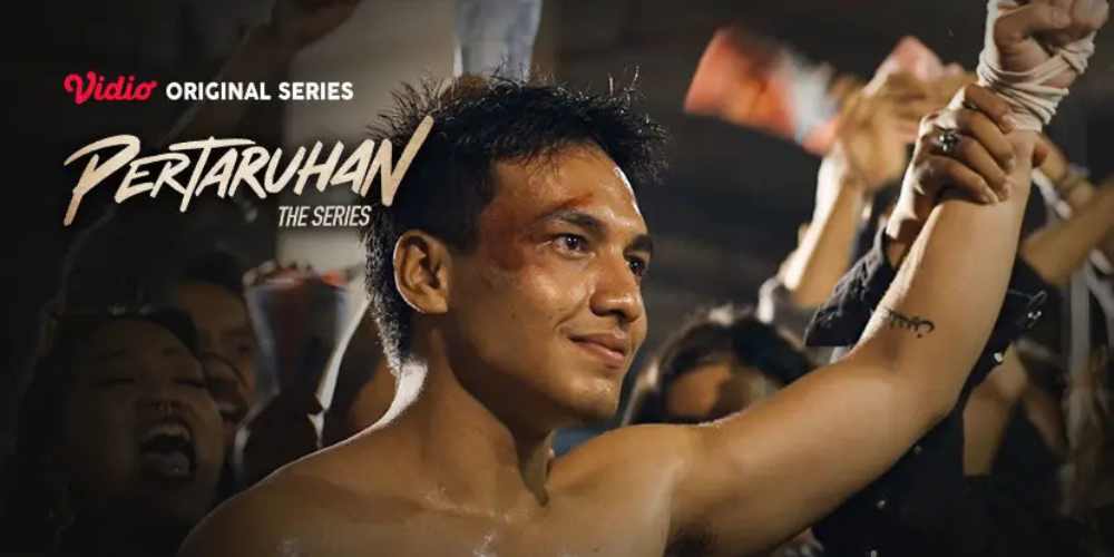 Jefri Nichole dalam adegan kemenangan dari Pertaruhan: The Series, mengangkat tangan di tengah sorakan penonton dengan wajah penuh luka dan determinasi.