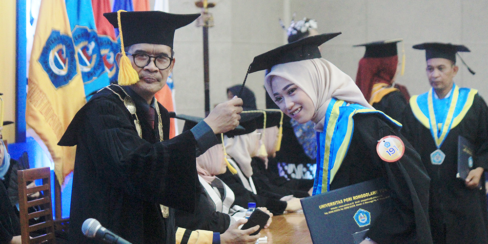 PROSESI SAKRAL: Prosesi pengalihan kuncir toga wisudawan oleh Rektor Unirow Tuban Dr. Warli M.Pd.