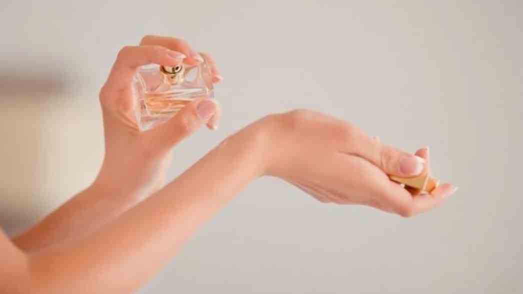 seseorang menyemprotkan parfum ke pergelangan tangan, menggambarkan tren &lsquo;scent personality&rsquo; yang makin populer di kalangan anak muda