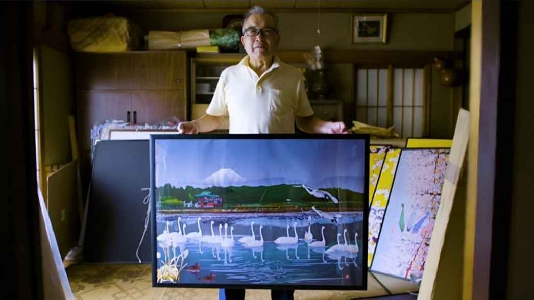 Tatsuo Horiuchi berpose dengan salah satu karyanya yang telah dicetak dan dibingkai, menunjukkan detail luar biasa yang seluruhnya dibuat menggunakan Microsoft Excel.