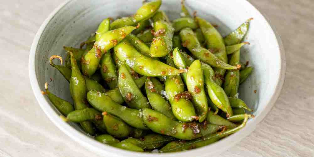 Semangkuk edamame rebus yang diberi bumbu gurih&mdash;camilan sehat kaya protein yang makin digemari anak muda karena enak, simpel, dan rendah kalori.