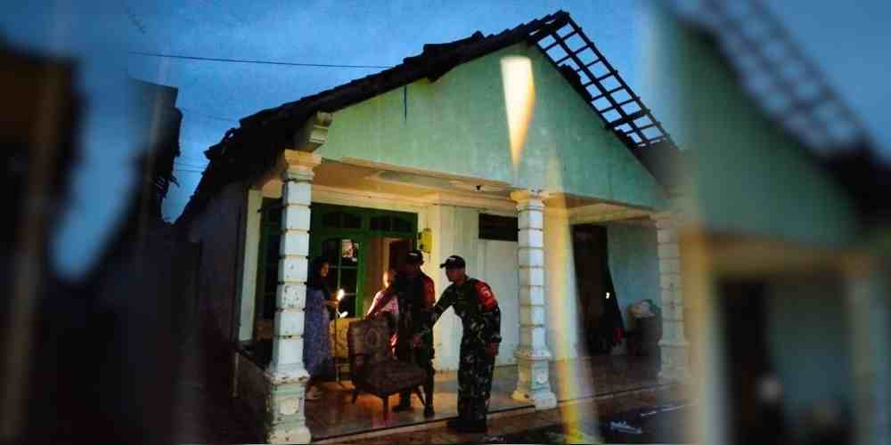 Petugas membantu warga mengevakuasi barang dari rumah yang rusak akibat putingbeliung di Tegalagung, Semanding.
