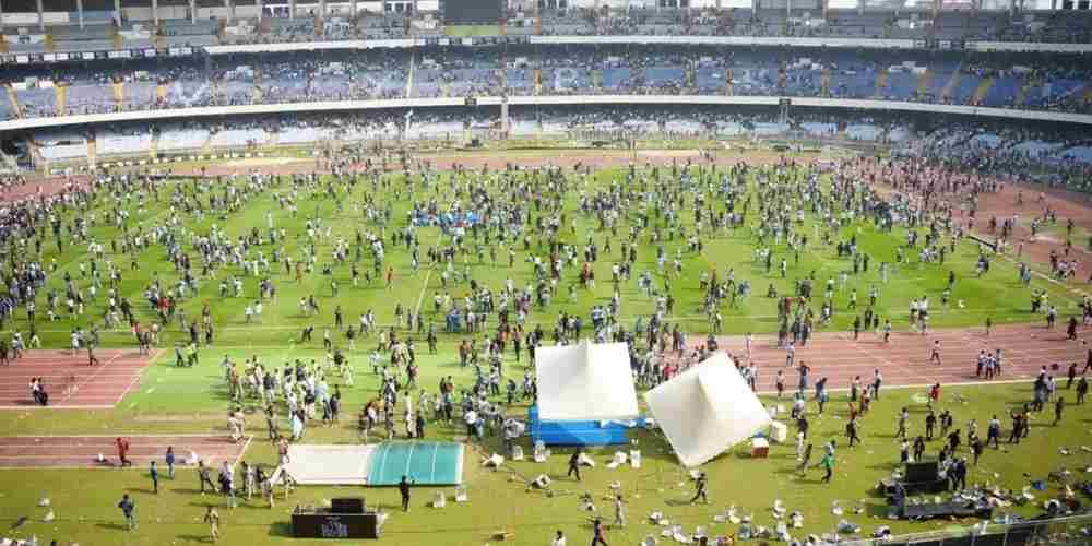 suasana kericuhan di dalam stadion yang memperlihatkan penonton turun ke lapangan dengan merusak fasilitas