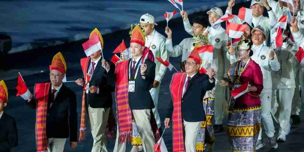 Kontingen Indonesia SEA Games 2025        saat parade pembukaan, mengenakan busana tradisional sambil mengibarkan Merah Putih sebagai simbol persatuan dan semangat juang bangsa.