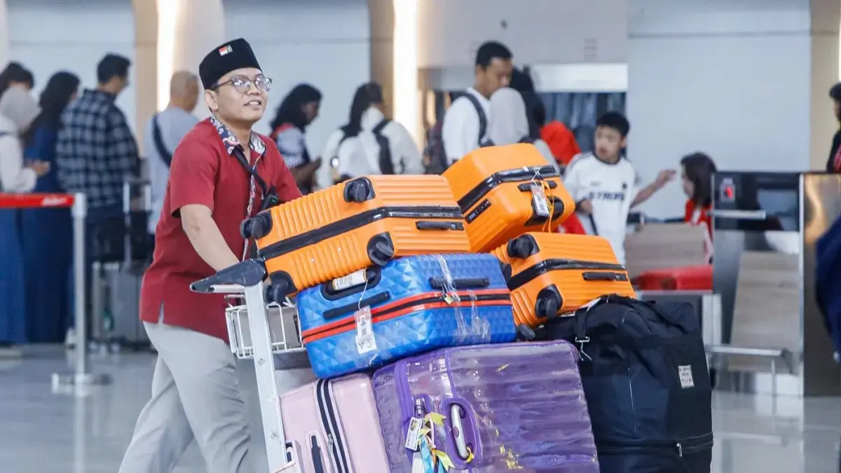 Petugas travel Haji dan Umroh menata koper calon jemaah di Terminal 2 Bandara Internasional Juanda, Jawa Timur, Senin (2/3/2025). (Riana Setiawan/ Jawa Pos)