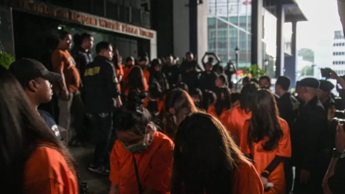Sejumlah tersangka judi online (judol) dikawal ketat oleh aparat Kepolisian keluar dari Hayam Wuruk Tower, Jakarta, Minggu (10/05/2026). Tim gabungan Bareskrim Polri dan Polda Metro Jaya mengamankan 321 orang WNA (HANUNG HAMBARA/JAWA POS)