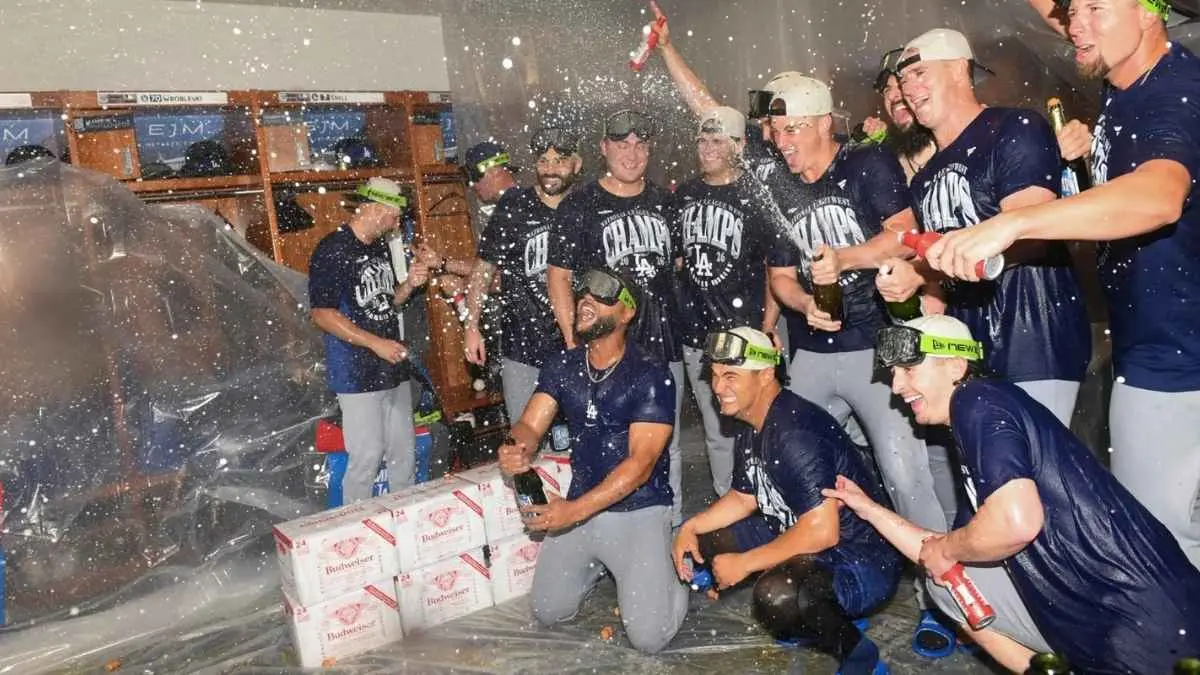 Los Angeles Dodgers merayakan kemenangan di ruang ganti setelah mengalahkan Cincinnati Reds dan memastikan gelar juara divisi untuk kelima kalinya secara beruntun. (Tanner Pearson / Associated Press)