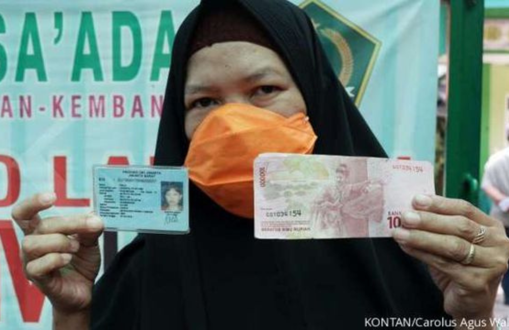 Para penerima bansos menunjukkan KTP serta uang yang didapatkan
