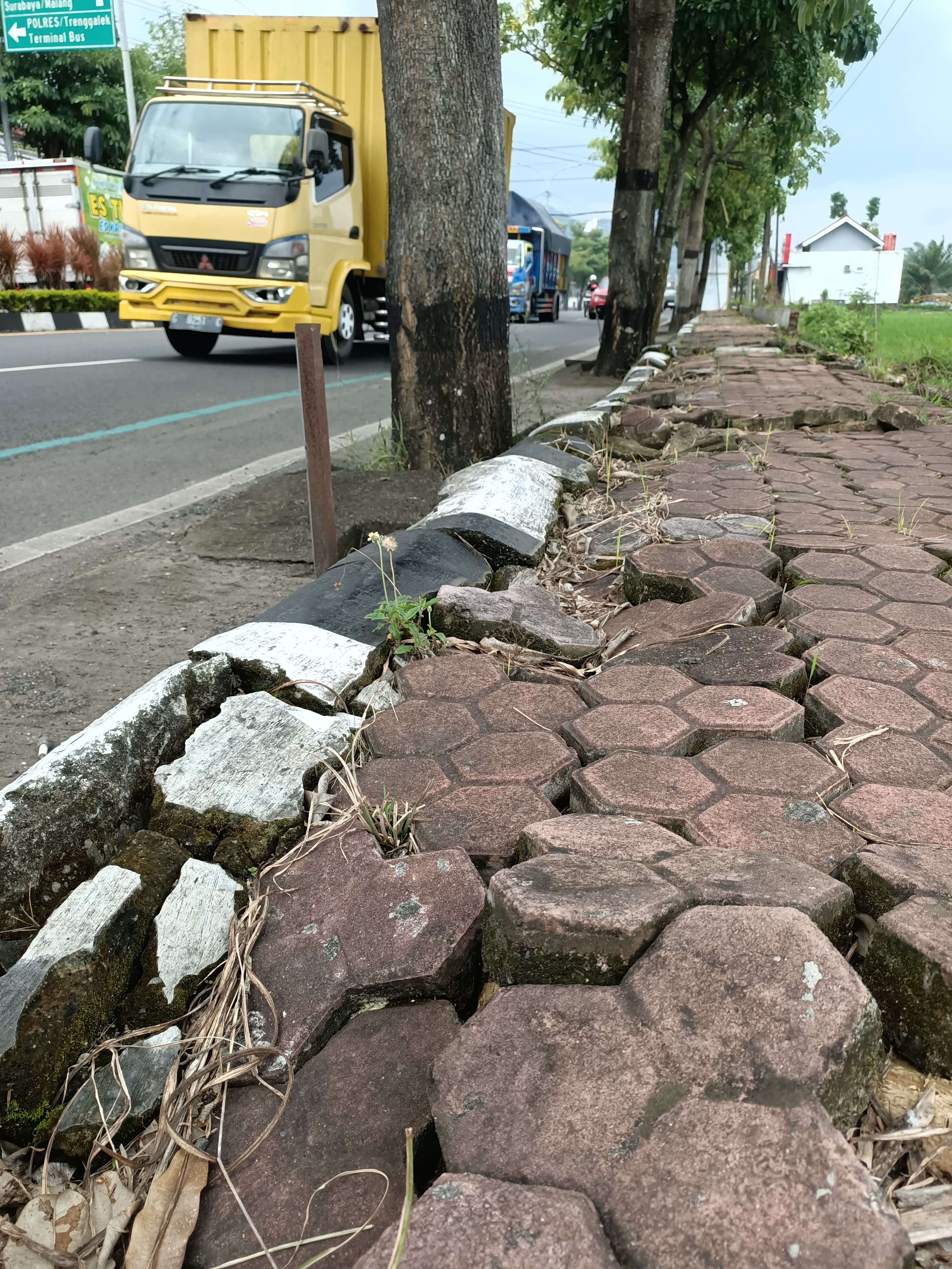 TIDAK RATA: Paving trotoar di Jalan Soekarno Hatta tak beraturan. Ini lantaran terdampak banjir.