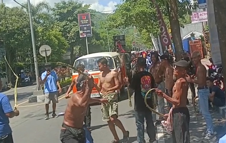 Tradisi tiban di tengah kota. Cambuk menyatu dengan doa, membelah jalan sebagai harapan.