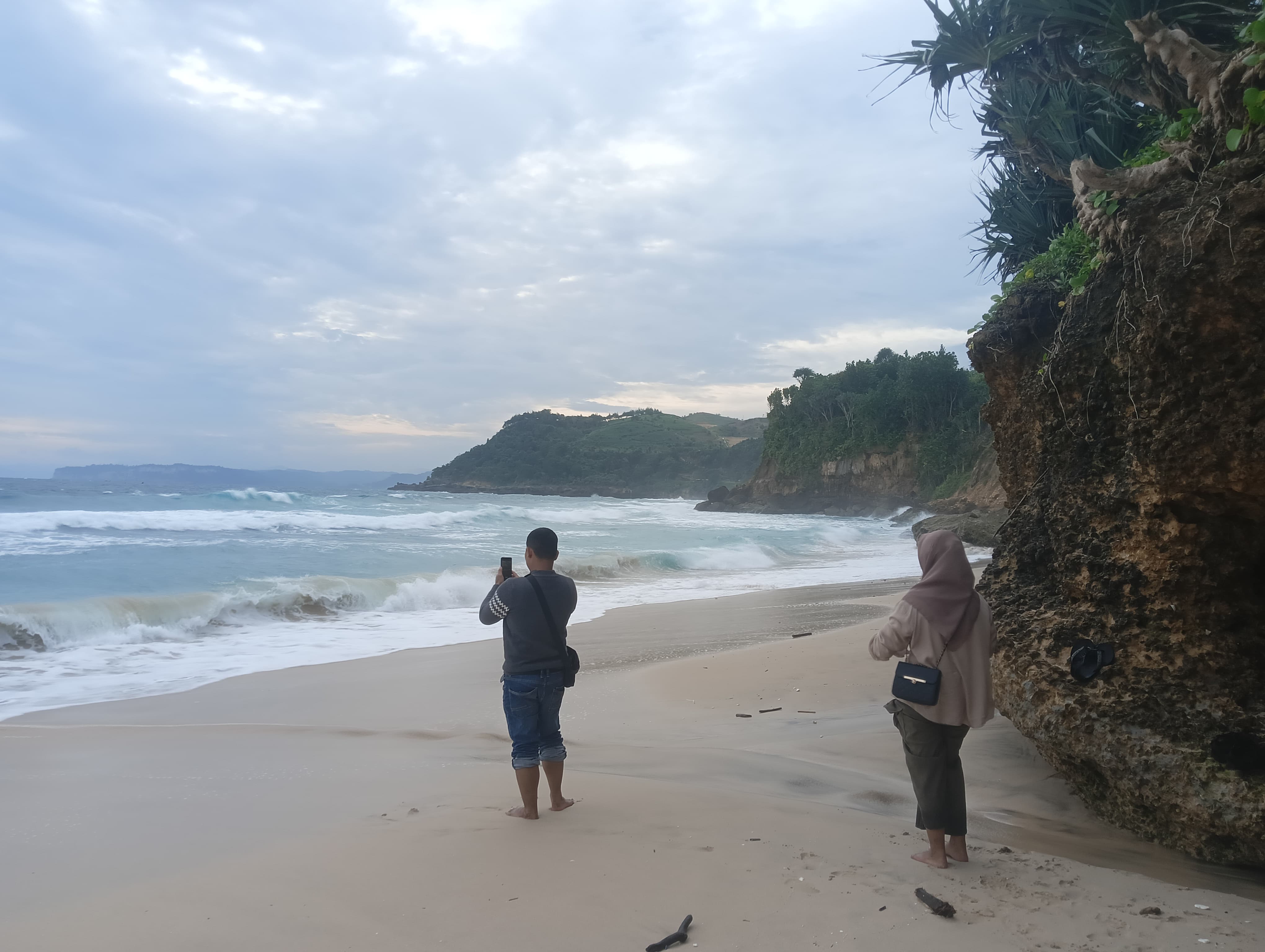 Seorang pengunjung sedang memotret keindahan pantai yang berada di Trenggalek. Perlu mengunjungi destinasi wisata yang antimaisntream saat sedang berlibur di Trenggalek