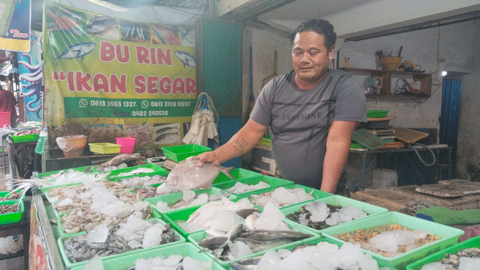 Salah seorang pedagang ikan di Pasar Tradisional sedang menata ikan yang dijual.