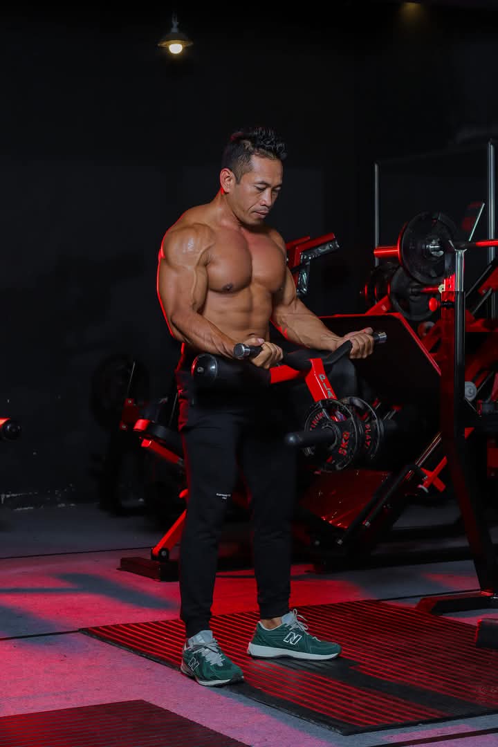 Cara melatih otot bisep yang benar dengan pegang alat mesin berdiri tegak angkat dumbbell ke arah bahu secara perlahan