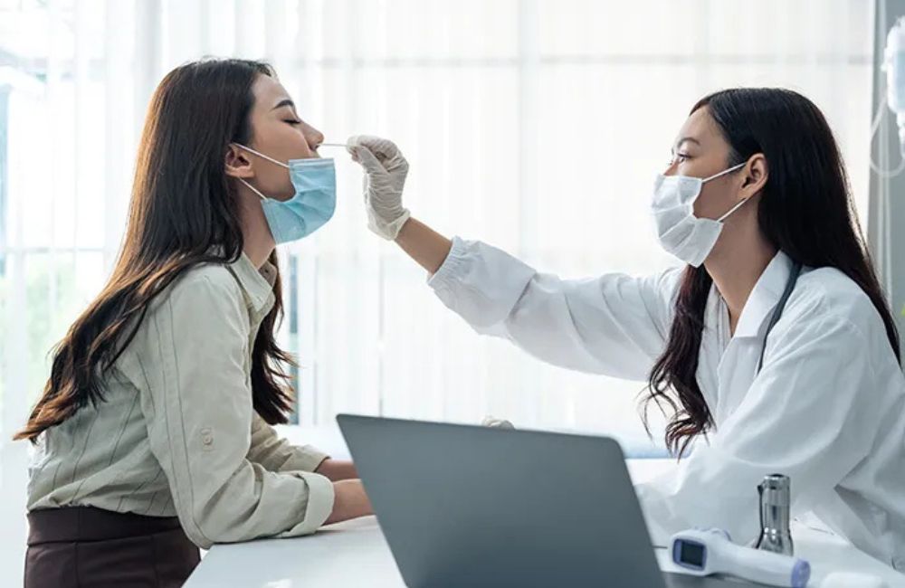 Seorang dokter sedang melakukan swab kepada pasiennya,