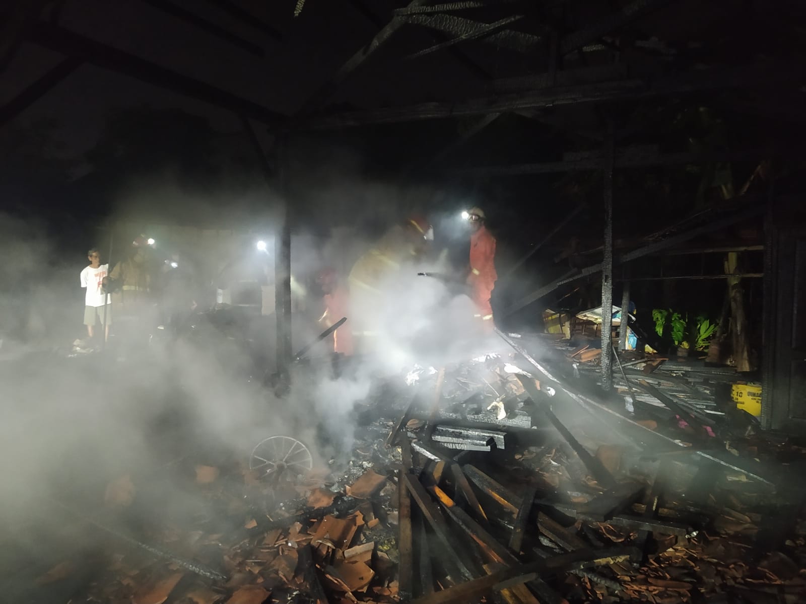 Petugas damkar Satpol PPK Trenggalek mengecek kondisi bangunan yang terbakar