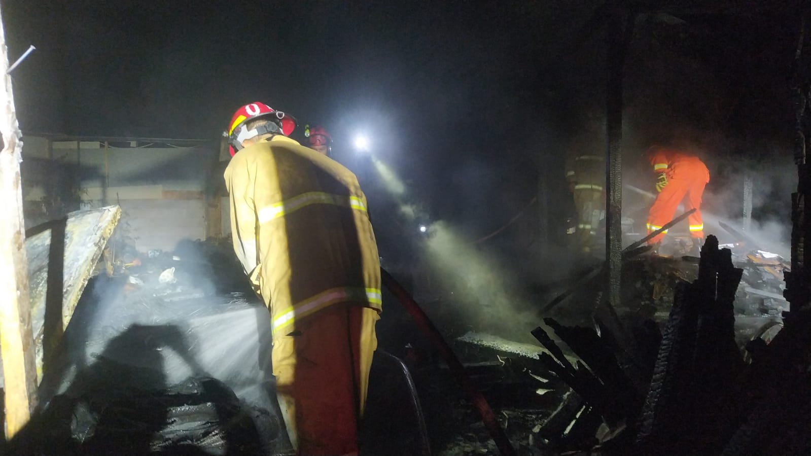 Petugas damkar mengecek kondisi rumah yang terbakar
