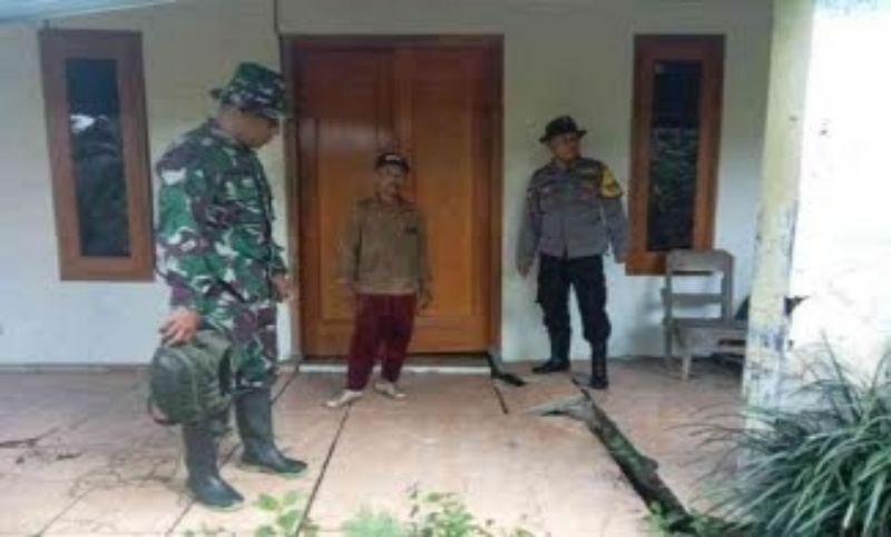 Petugas mengecek kondisi rumah di Tugu yang terkena tanah gerak