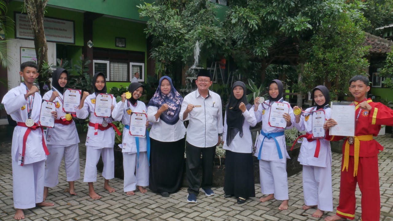 Ahzan winarto kepala MTsN 2 Trenggalek berfoto bareng 7 siswa berprestasi
