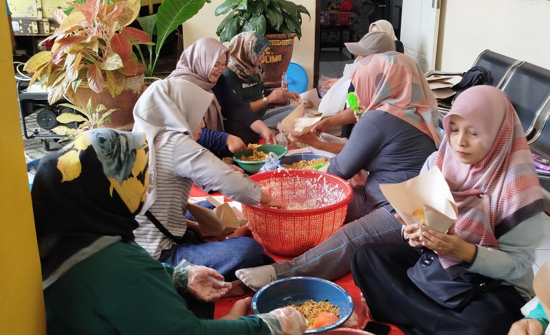 Relawan sedang membantu membuat nasi bungkus di dapur umum untuk korban banjir di Kecamatan Watulimo.