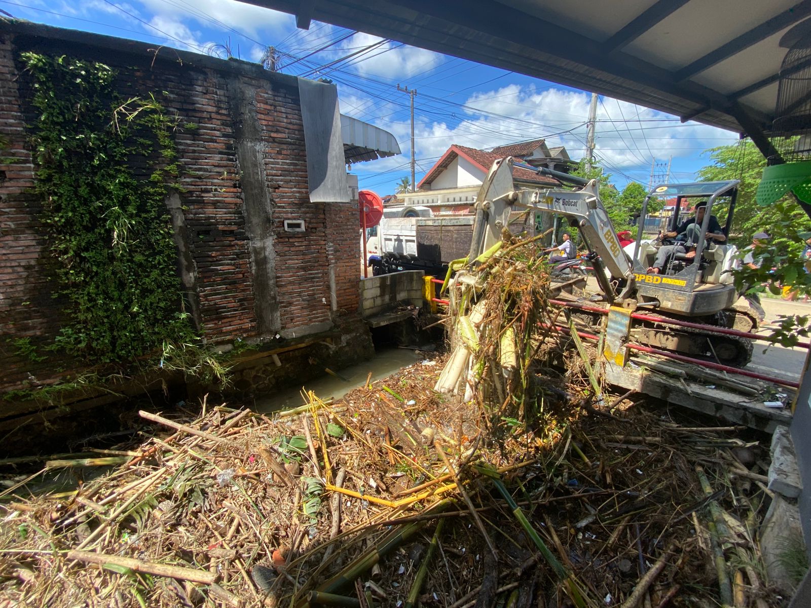 Alat berat membersihkan sampah yang menyumbang Sungai Tawang di Desa Tasikmadu. (DR PERDANA/RADAR TRENGGALEK)