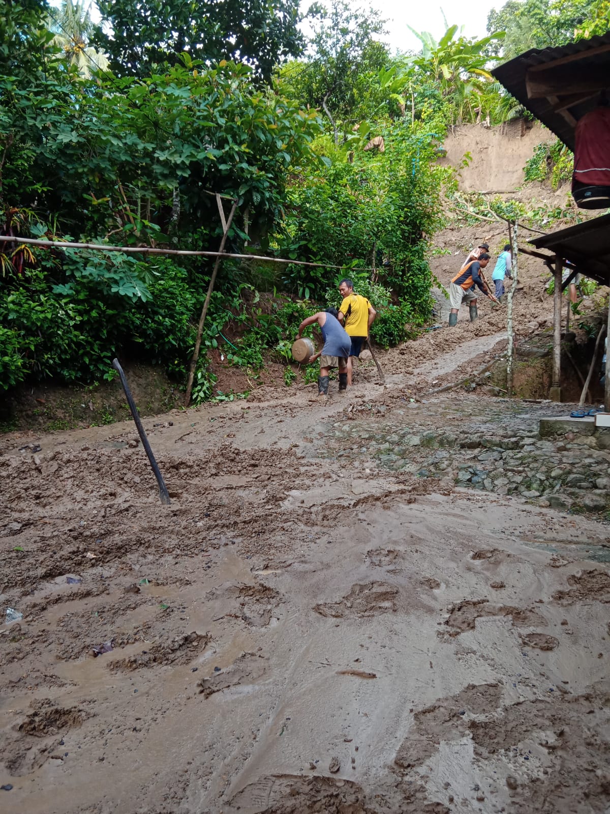Warga Desa Margomulyo Trenggalek gotong Royong bersihkan lumpur di jalan jalan setelah banjir