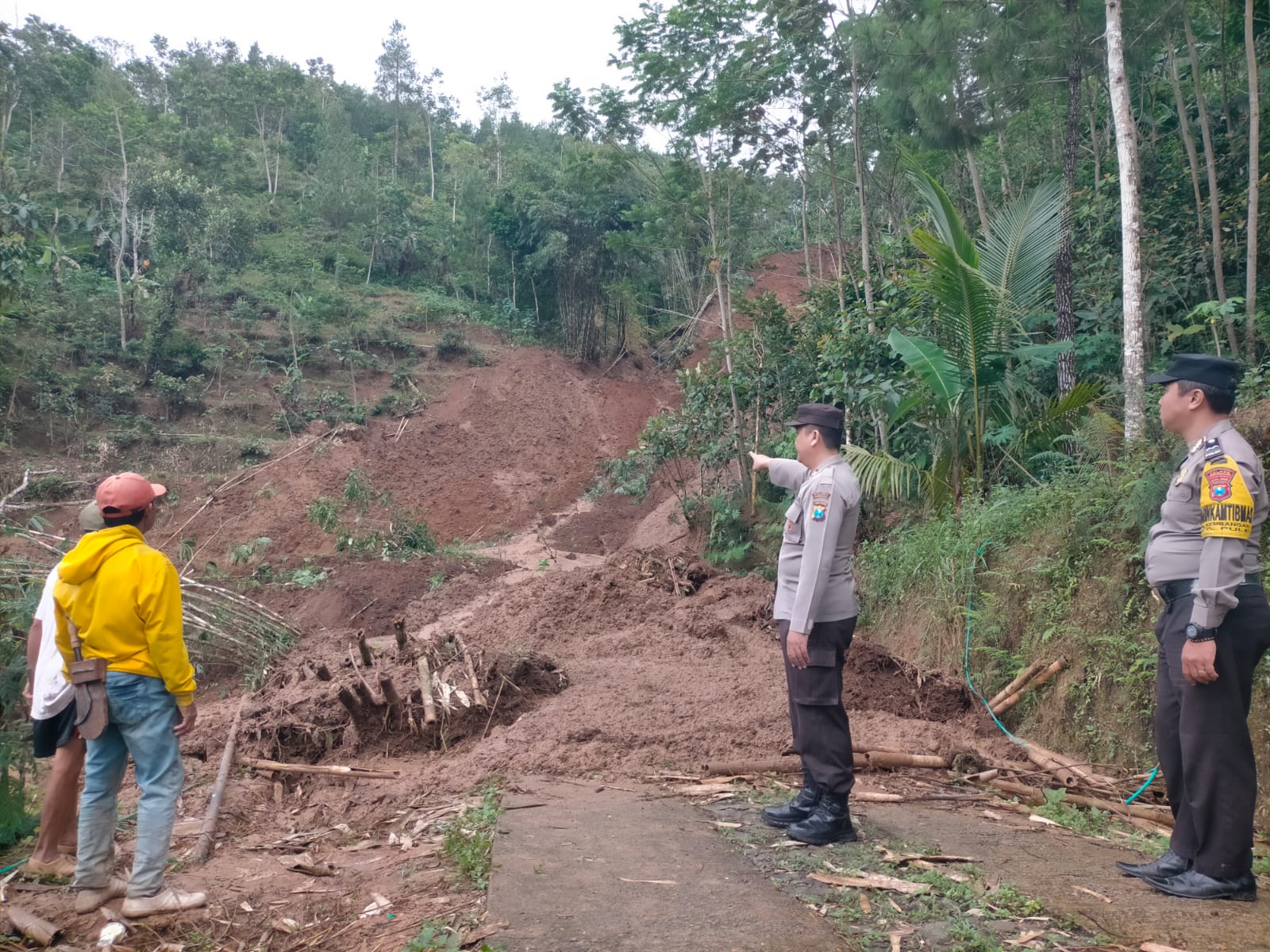Polisi meninjau lokasi longsor do Pakek, Pule yang menutup jalan