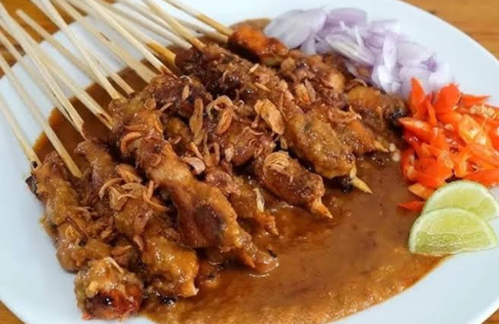 Sate Ayam Madura terkenal dengan bumbu kacangnya yang kental dan gurih.